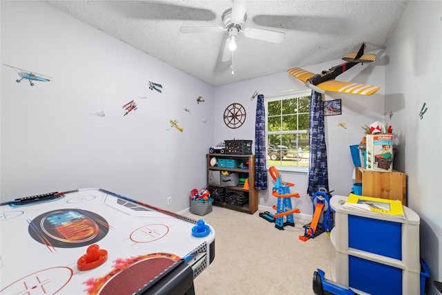 recreation room featuring ceiling fan, a textured ceiling, and carpet flooring