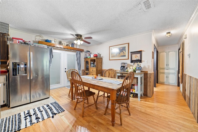 dining room with ceiling fan, light wood-type flooring, ornamental molding, and a textured ceiling