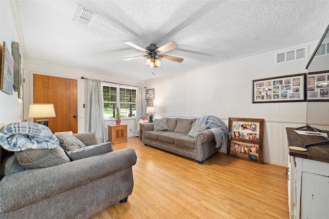 living room featuring crown molding, a textured ceiling, and light hardwood / wood-style floors