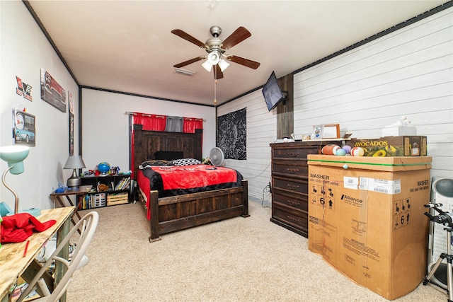 bedroom with ceiling fan, light carpet, and wooden walls