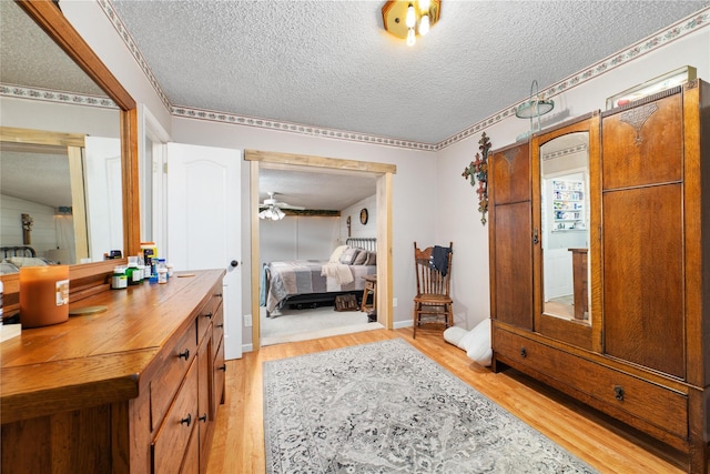 bathroom featuring ceiling fan, vanity, a textured ceiling, and hardwood / wood-style floors