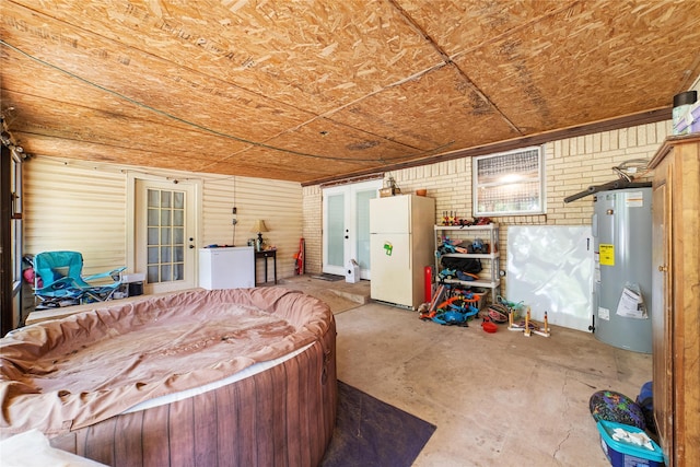 interior space with wooden ceiling, brick wall, electric water heater, and concrete floors