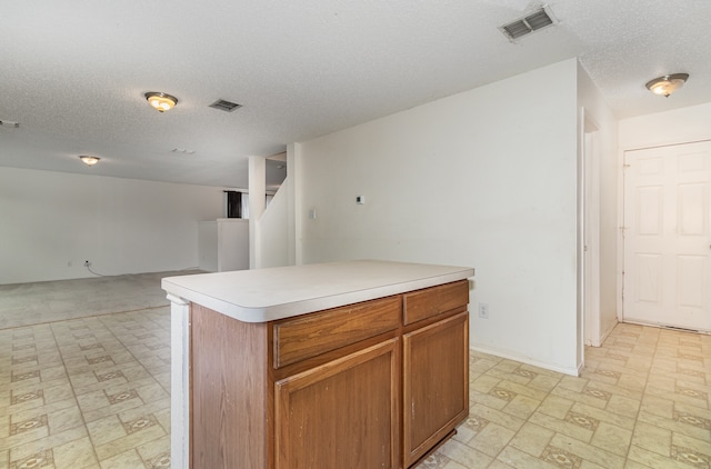 kitchen featuring a textured ceiling and a center island