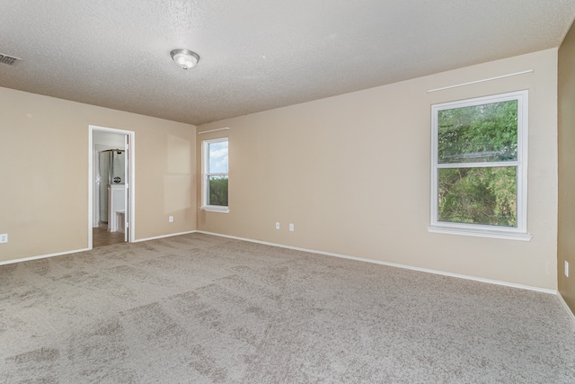 unfurnished room featuring a textured ceiling and carpet flooring