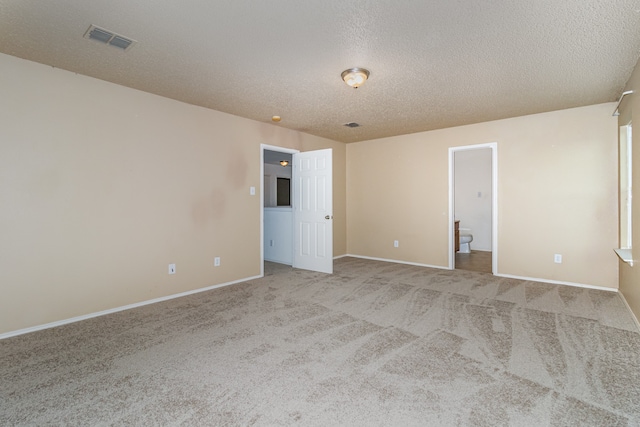 carpeted spare room with a textured ceiling