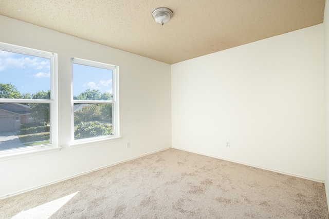 carpeted spare room with a textured ceiling