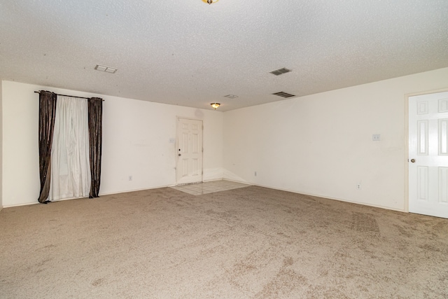 carpeted spare room featuring a textured ceiling