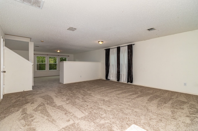 unfurnished living room with a textured ceiling and carpet floors