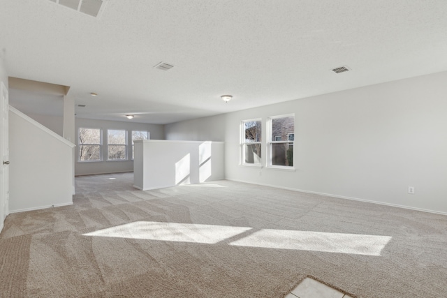 unfurnished room featuring light carpet and a textured ceiling