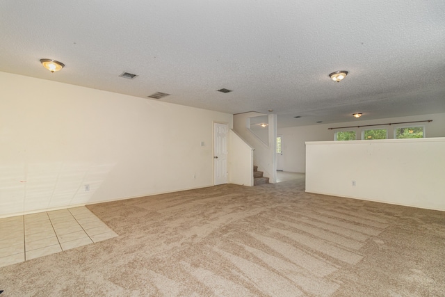 carpeted empty room featuring a textured ceiling