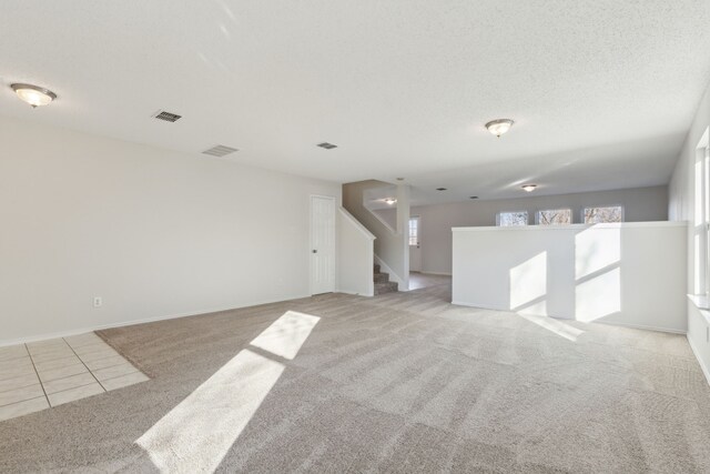 carpeted spare room featuring a textured ceiling