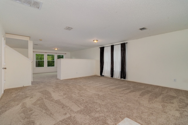 carpeted empty room with a textured ceiling