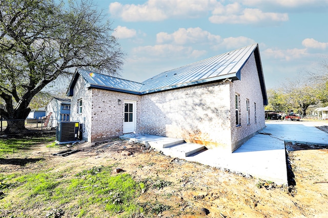 back of house with central AC unit