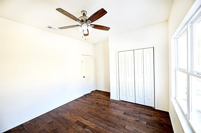 unfurnished bedroom featuring ceiling fan, dark hardwood / wood-style flooring, and a closet