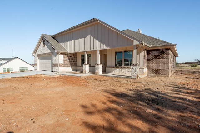 rear view of house with a garage and covered porch