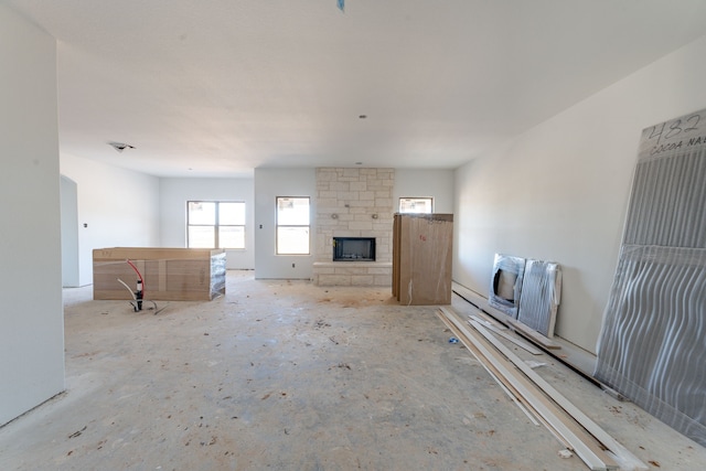 unfurnished living room featuring a stone fireplace