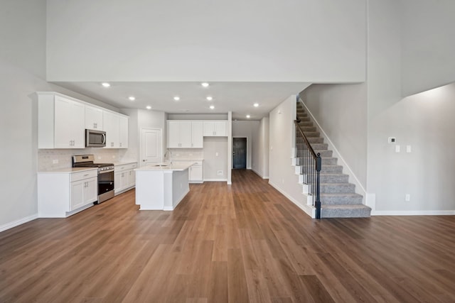 kitchen featuring hardwood / wood-style flooring, stainless steel appliances, and white cabinetry