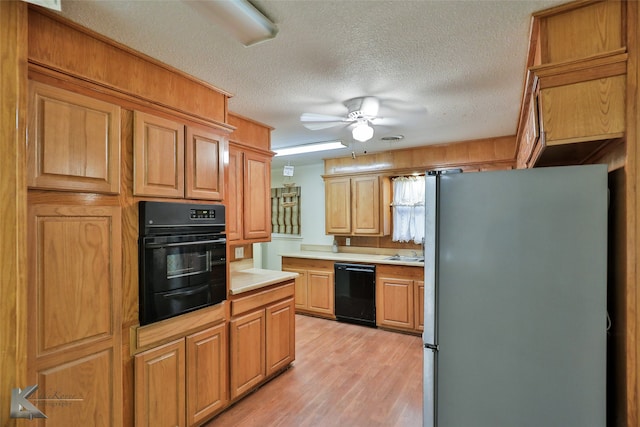 kitchen featuring black appliances, a textured ceiling, ceiling fan, and light hardwood / wood-style floors