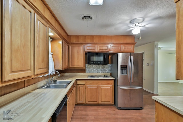 kitchen featuring hardwood / wood-style floors, a textured ceiling, black appliances, sink, and ceiling fan