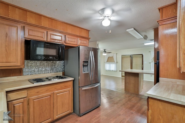 kitchen featuring hardwood / wood-style floors, ceiling fan, stainless steel fridge with ice dispenser, tasteful backsplash, and a textured ceiling