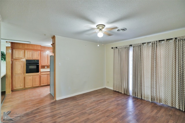 interior space featuring dark wood-type flooring, ceiling fan, and a textured ceiling