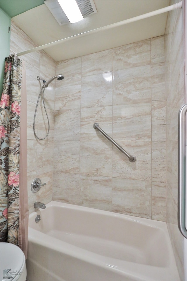 bathroom with toilet and shower / tub combo with curtain