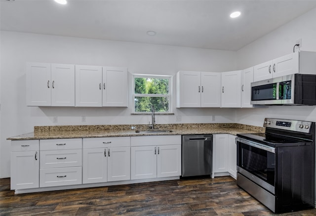 kitchen with stone counters, sink, dark wood-type flooring, white cabinets, and appliances with stainless steel finishes