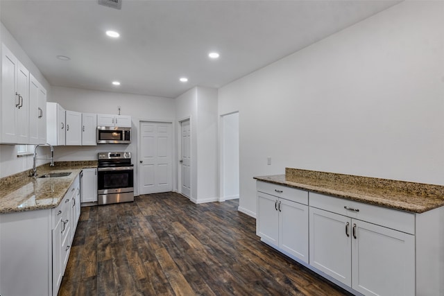 kitchen with white cabinetry, sink, dark wood-type flooring, stone countertops, and appliances with stainless steel finishes