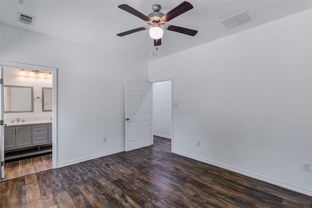 unfurnished bedroom featuring ensuite bathroom, ceiling fan, and dark wood-type flooring