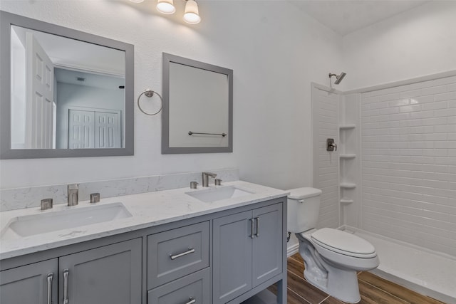 bathroom with hardwood / wood-style floors, toilet, a shower, and vanity