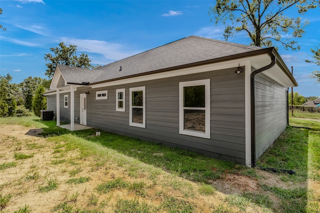 rear view of house with a yard and cooling unit