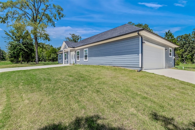 view of side of property with a yard and a garage