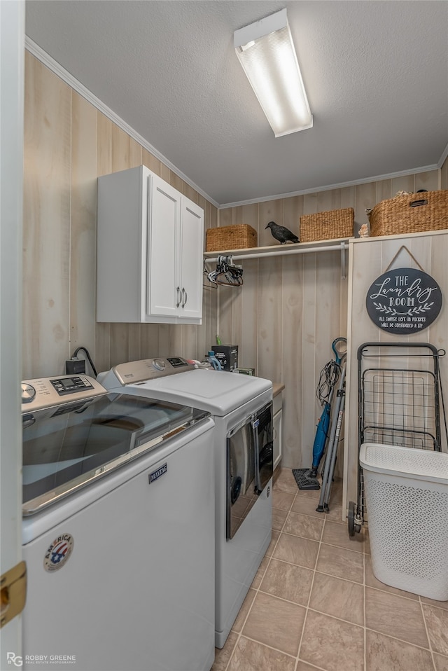 washroom with cabinets, separate washer and dryer, light tile patterned floors, and a textured ceiling