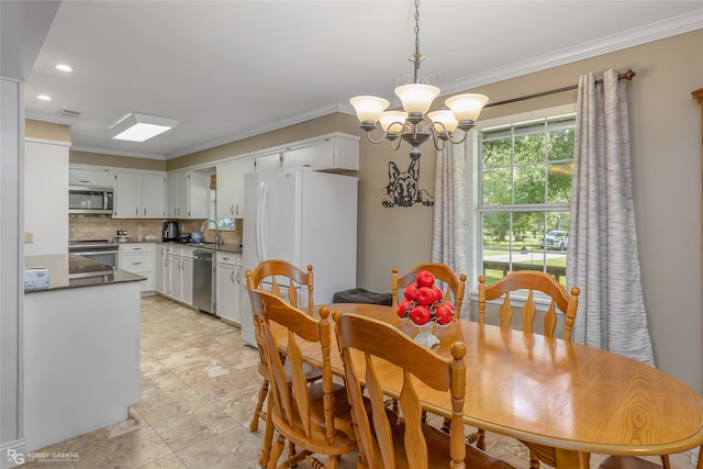 tiled dining room featuring an inviting chandelier, sink, and ornamental molding