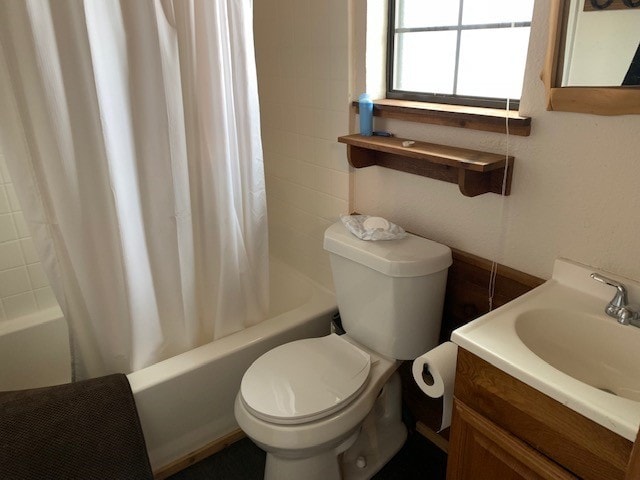 bathroom with shower / bath combination with curtain, toilet, and vanity