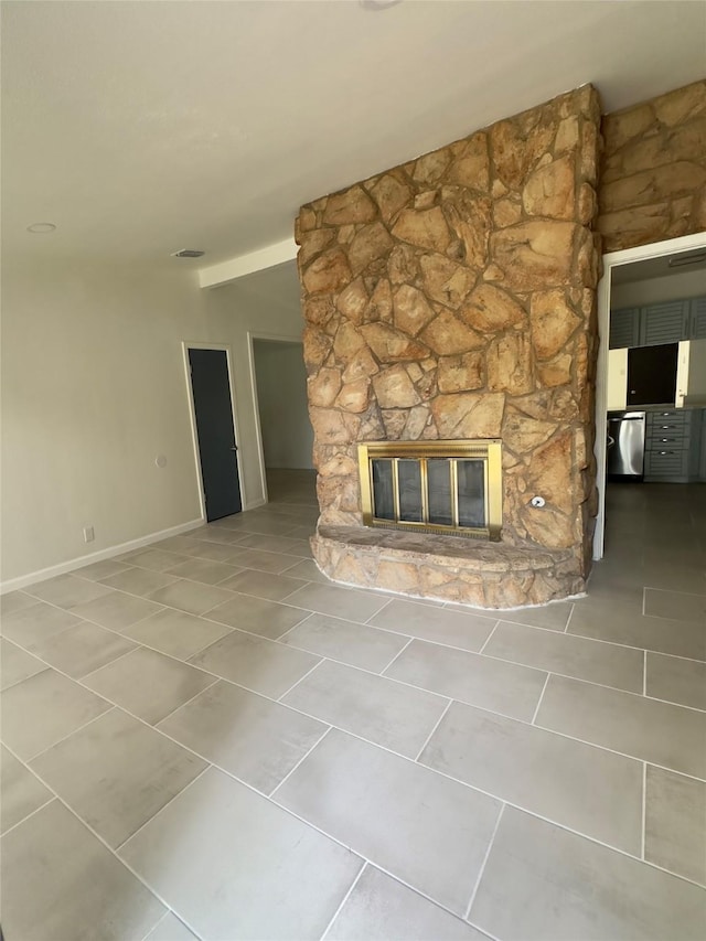 unfurnished living room featuring a stone fireplace and tile patterned flooring