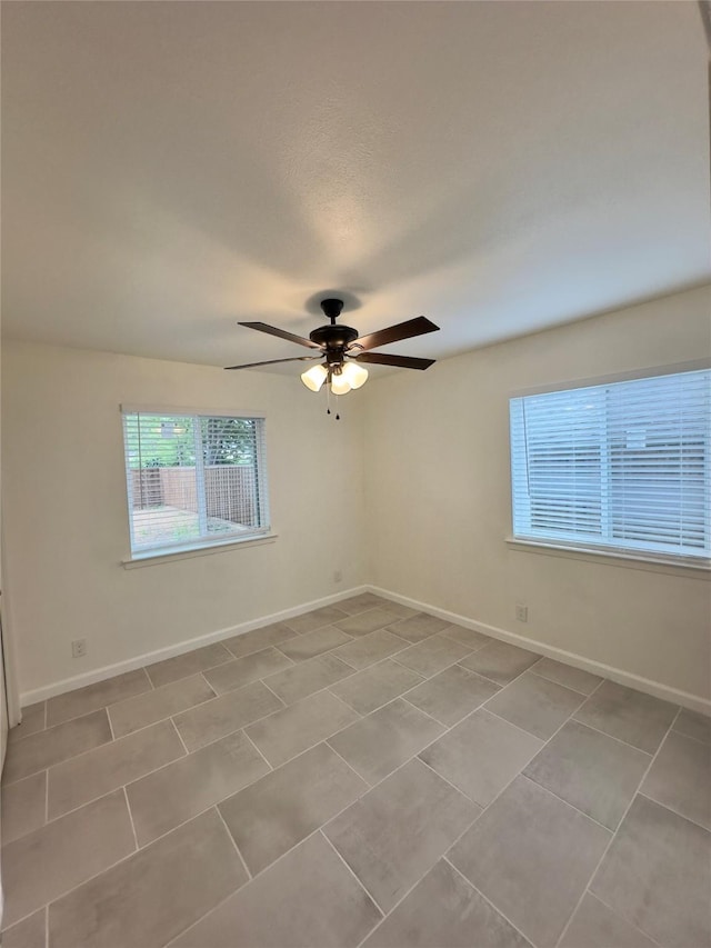 spare room featuring ceiling fan and light tile patterned floors