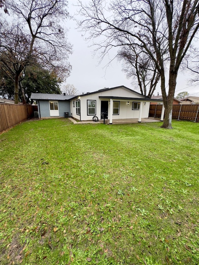 back of house with a lawn and a patio