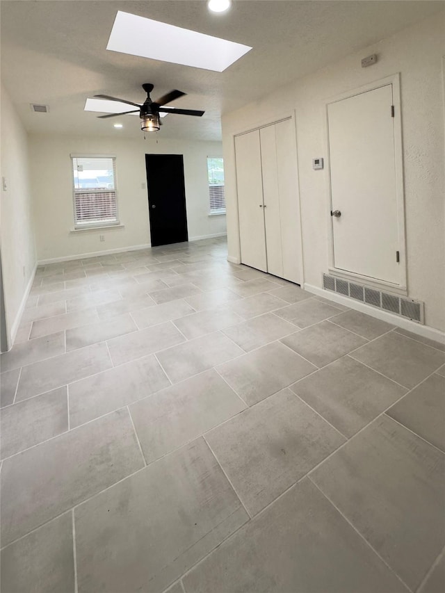 empty room with a skylight and ceiling fan