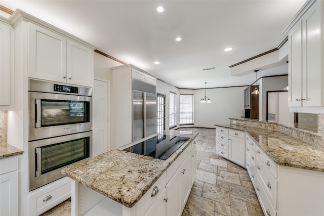 kitchen with decorative light fixtures, light tile patterned flooring, a center island, light stone counters, and appliances with stainless steel finishes