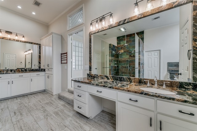 bathroom with ornamental molding, tiled shower, and vanity