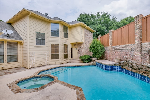 view of swimming pool with an in ground hot tub