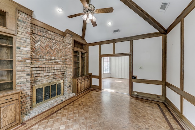 unfurnished living room with ceiling fan, light parquet flooring, a brick fireplace, brick wall, and lofted ceiling with beams