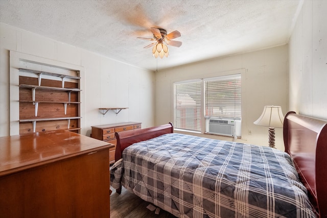 bedroom with a textured ceiling, ceiling fan, hardwood / wood-style floors, and cooling unit