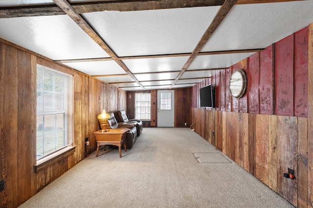 living area featuring wood walls, light colored carpet, and coffered ceiling