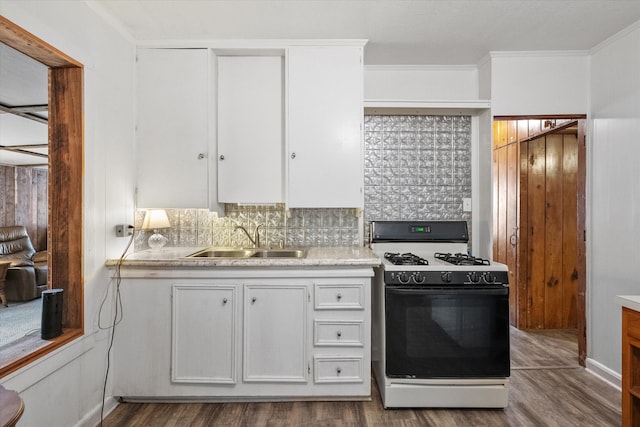 kitchen featuring tasteful backsplash, white cabinets, white gas range oven, light hardwood / wood-style floors, and sink