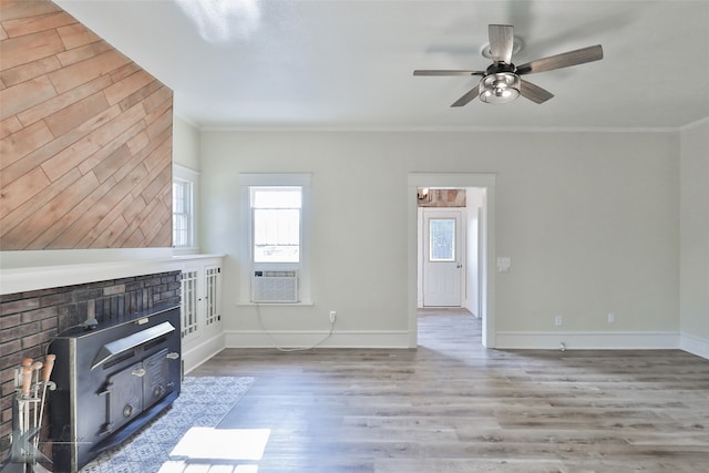 unfurnished living room featuring a fireplace, ceiling fan, light wood-type flooring, cooling unit, and ornamental molding