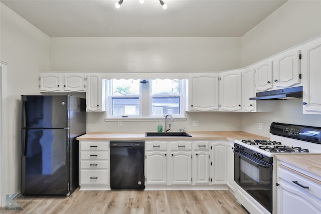 kitchen with white cabinetry, black appliances, light wood-type flooring, sink, and wood counters