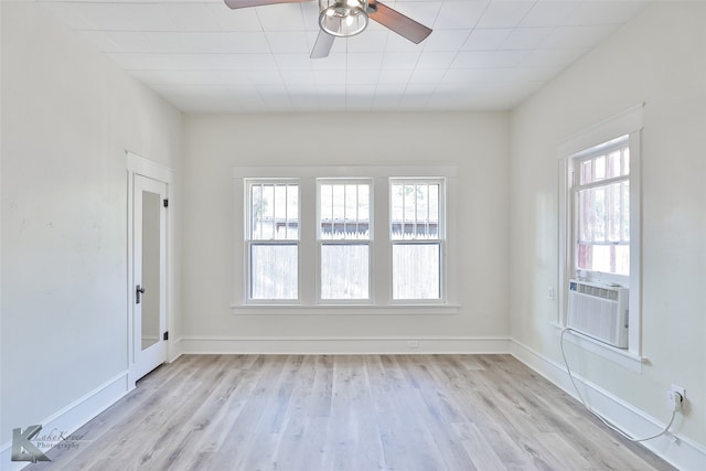 empty room with light hardwood / wood-style flooring, ceiling fan, and cooling unit