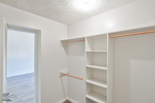 walk in closet with hardwood / wood-style floors